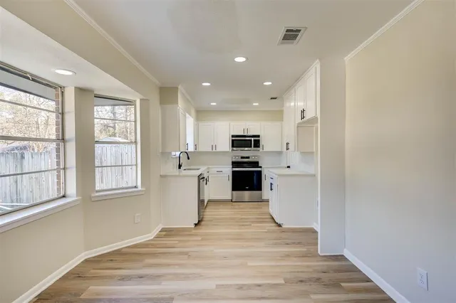 a view of kitchen with wooden floor and electronic appliances