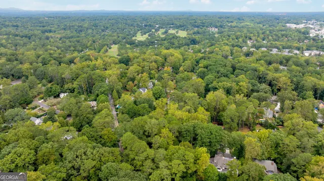an aerial view of residential house with outdoor space and trees all around