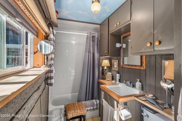 a bathroom with a sink a toilet a mirror and shower