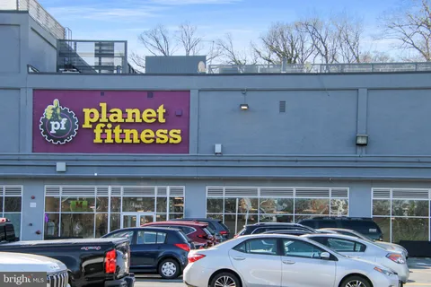 a front view of multi story commercial building with retail shops