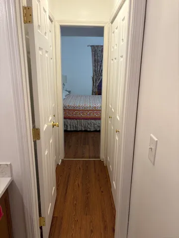 a view of a hallway with wooden floor and staircase