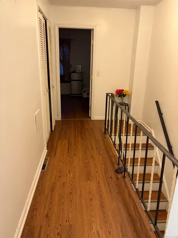 a view of a hallway with wooden floor and staircase