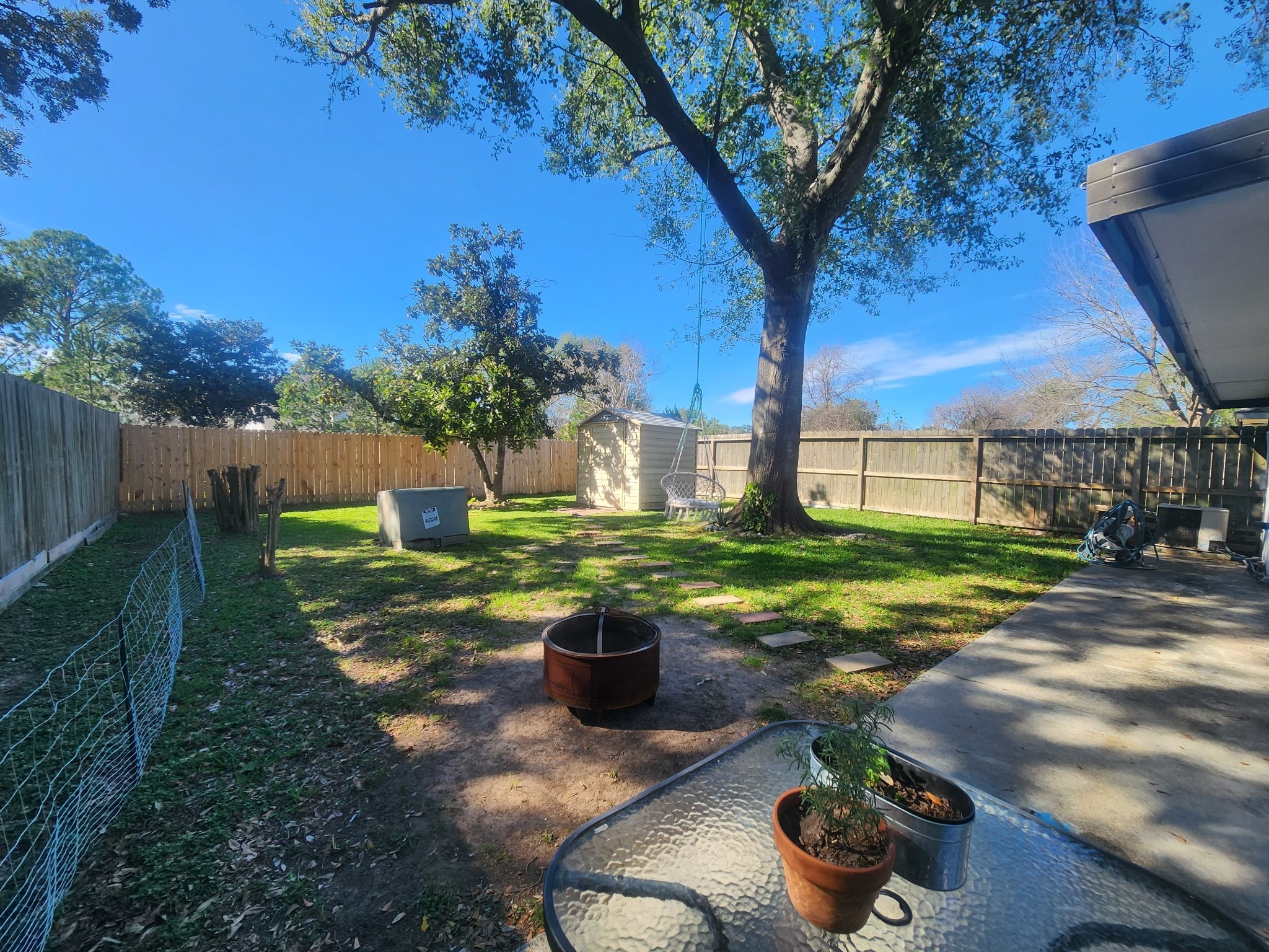 13715 Vickston Lane Houston, TX 77014 - Photo 12 of 12 a view of a backyard with table and chairs potted plants and a large tree