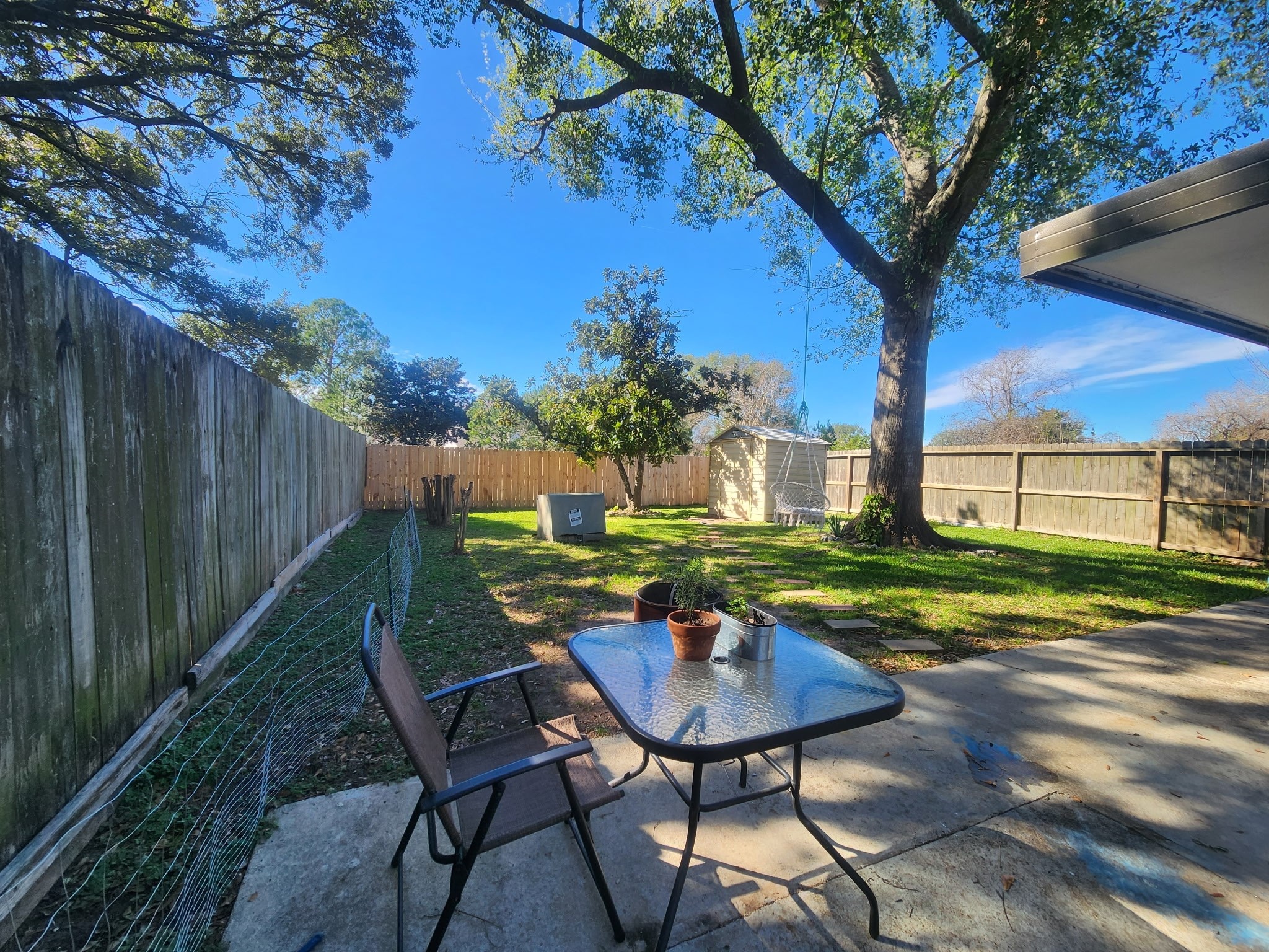 13715 Vickston Lane Houston, TX 77014 - Photo 10 of 12 a view of a backyard with table and chairs with wooden fence and plants
