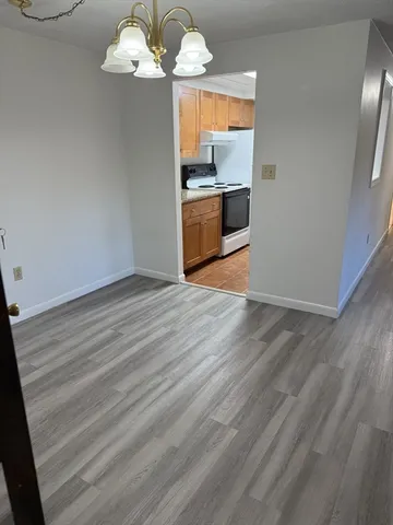 an empty room with wooden floor sink and mirror