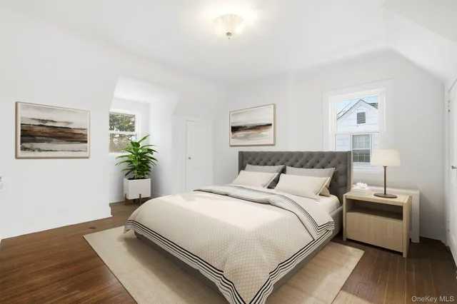 a bedroom with bed and a potted plant