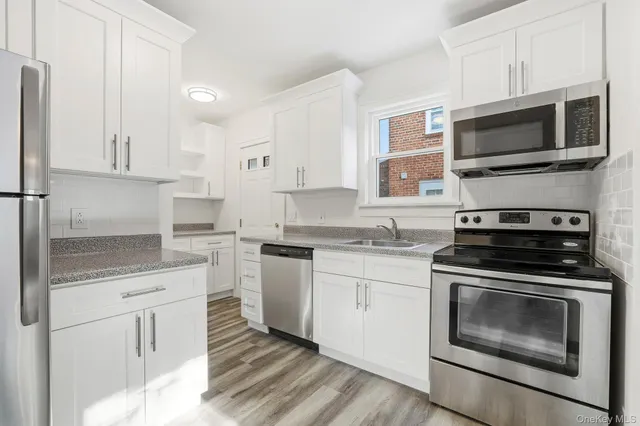 a kitchen with cabinets stainless steel appliances and a sink