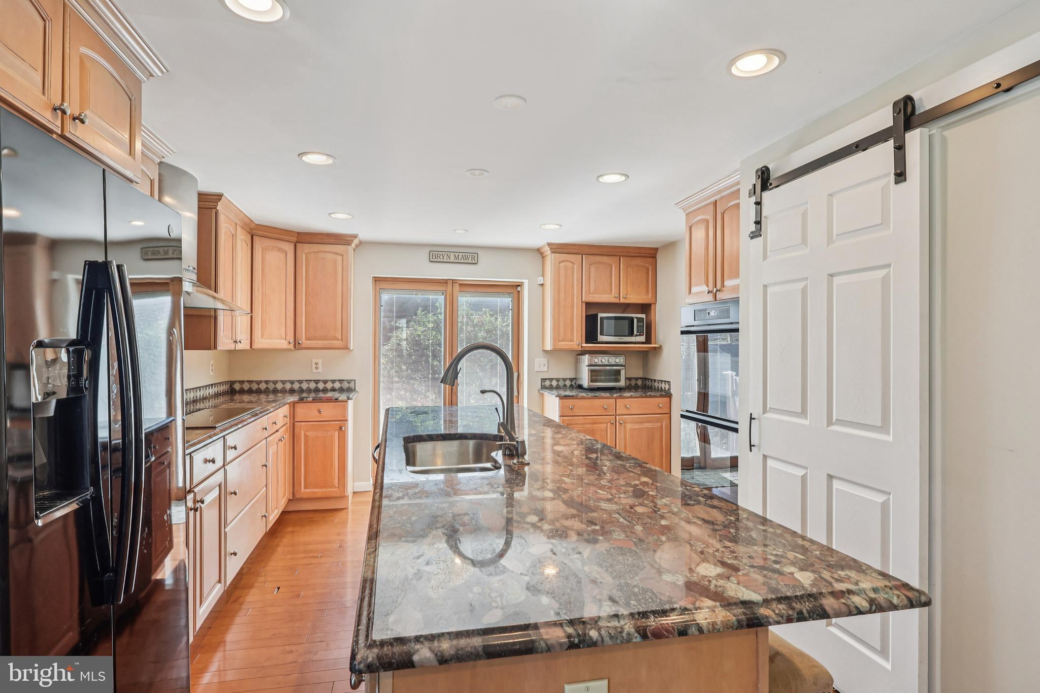 131 Fairfax Road Bryn Mawr, PA 19010 - Photo 8 of 29 a kitchen with stainless steel appliances granite countertop a refrigerator a stove top oven and white cabinets