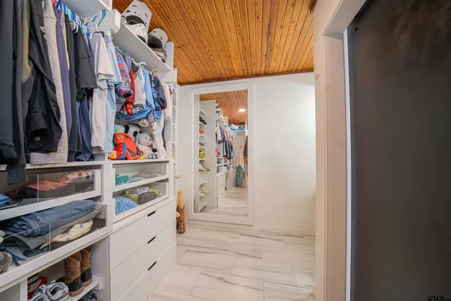 a view of walk in closet with clothes and shoes
