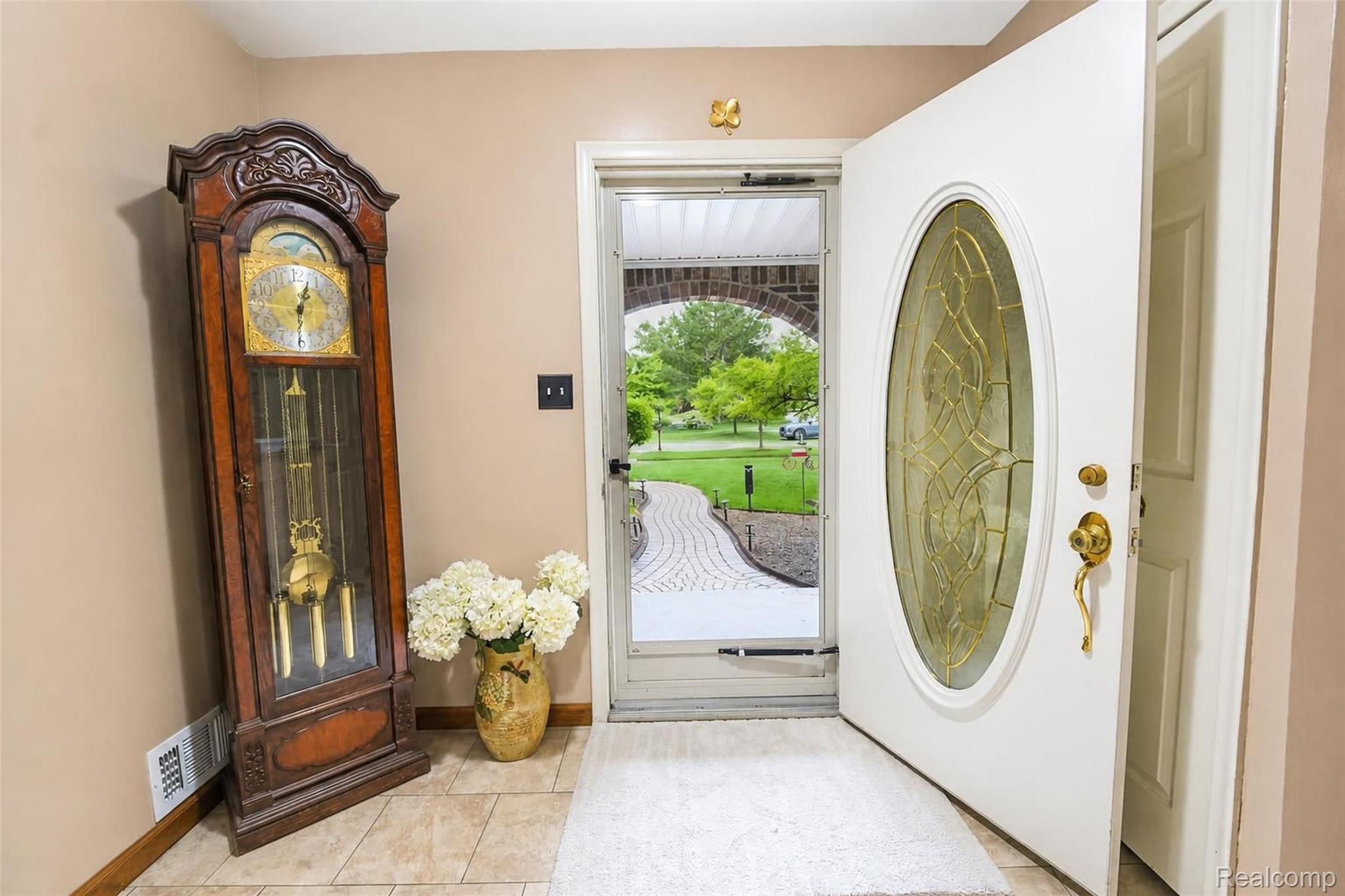 41768 Hanford Road Canton, MI 48187 - Photo 12 of 28 Entryway featuring a white door with an oval decorative glass insert, a full-lite storm door, and tile flooring