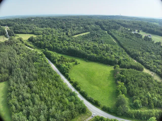 an aerial view of residential houses with outdoor space and trees