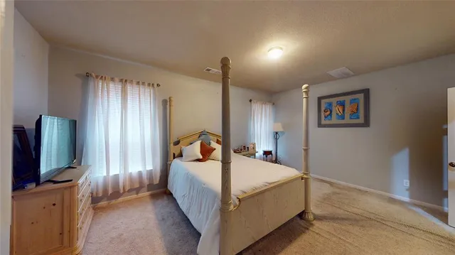 a living room with a bed furniture and a flat screen tv