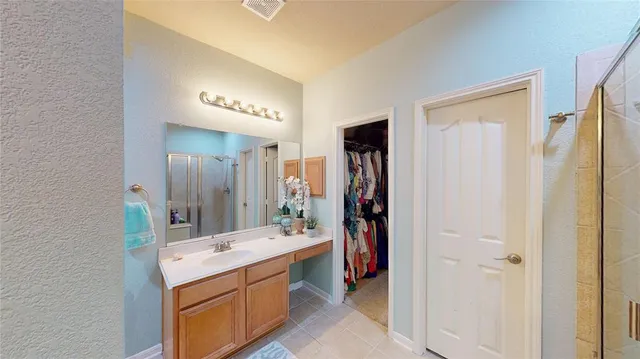 a bathroom with a double vanity sink mirror and shower