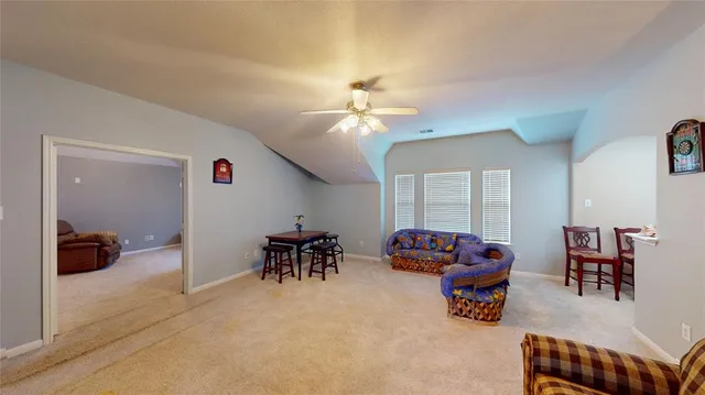 a living room with furniture and a ceiling fan