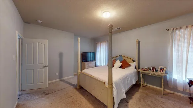 a spacious bedroom with a bed and a window