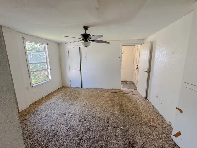 a view of a livingroom with a ceiling fan and window