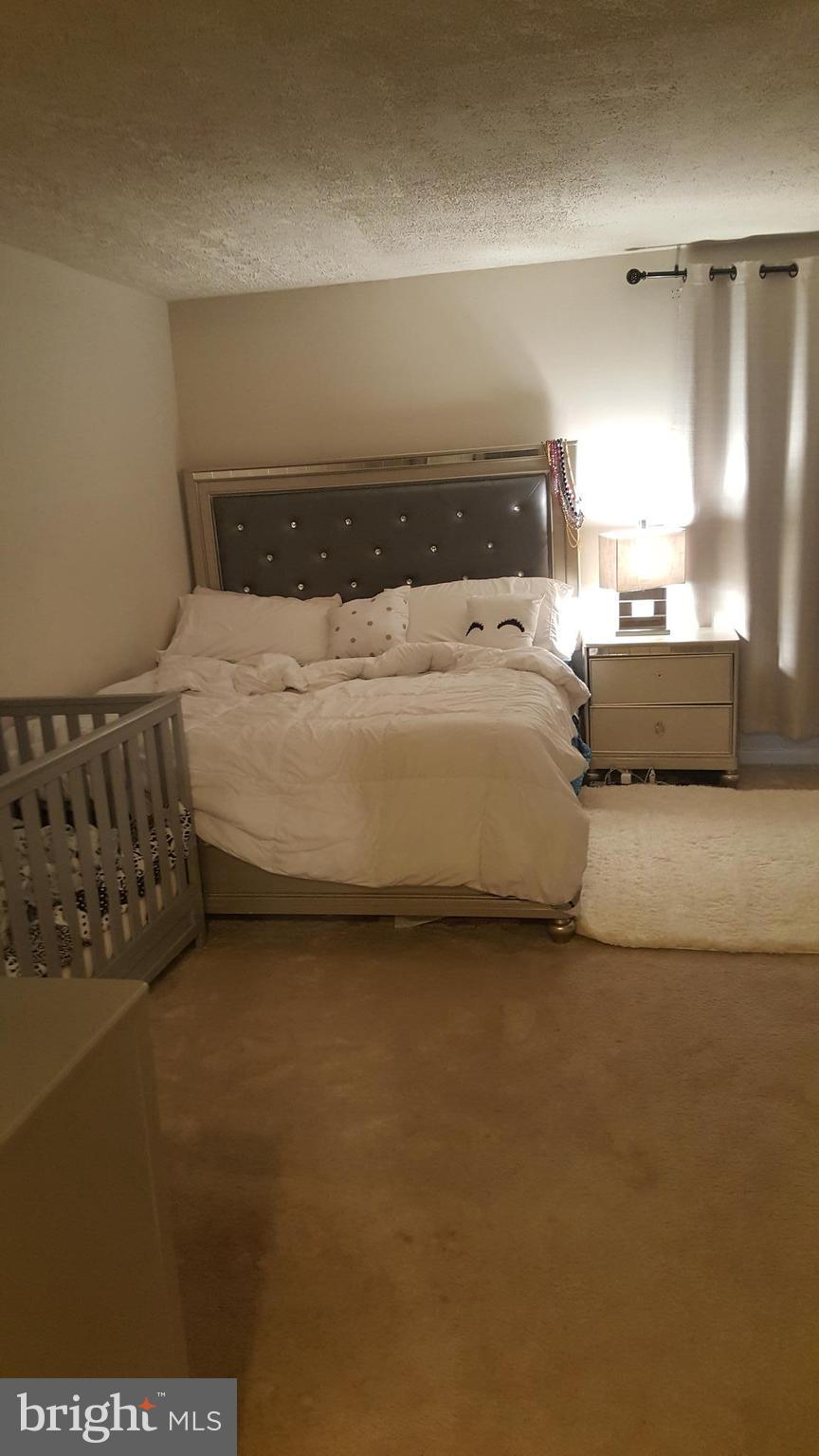 8017 Mandan Road, Unit 302 Greenbelt, MD 20770 - Photo 2 of 7 a bedroom with a bed and a night stand