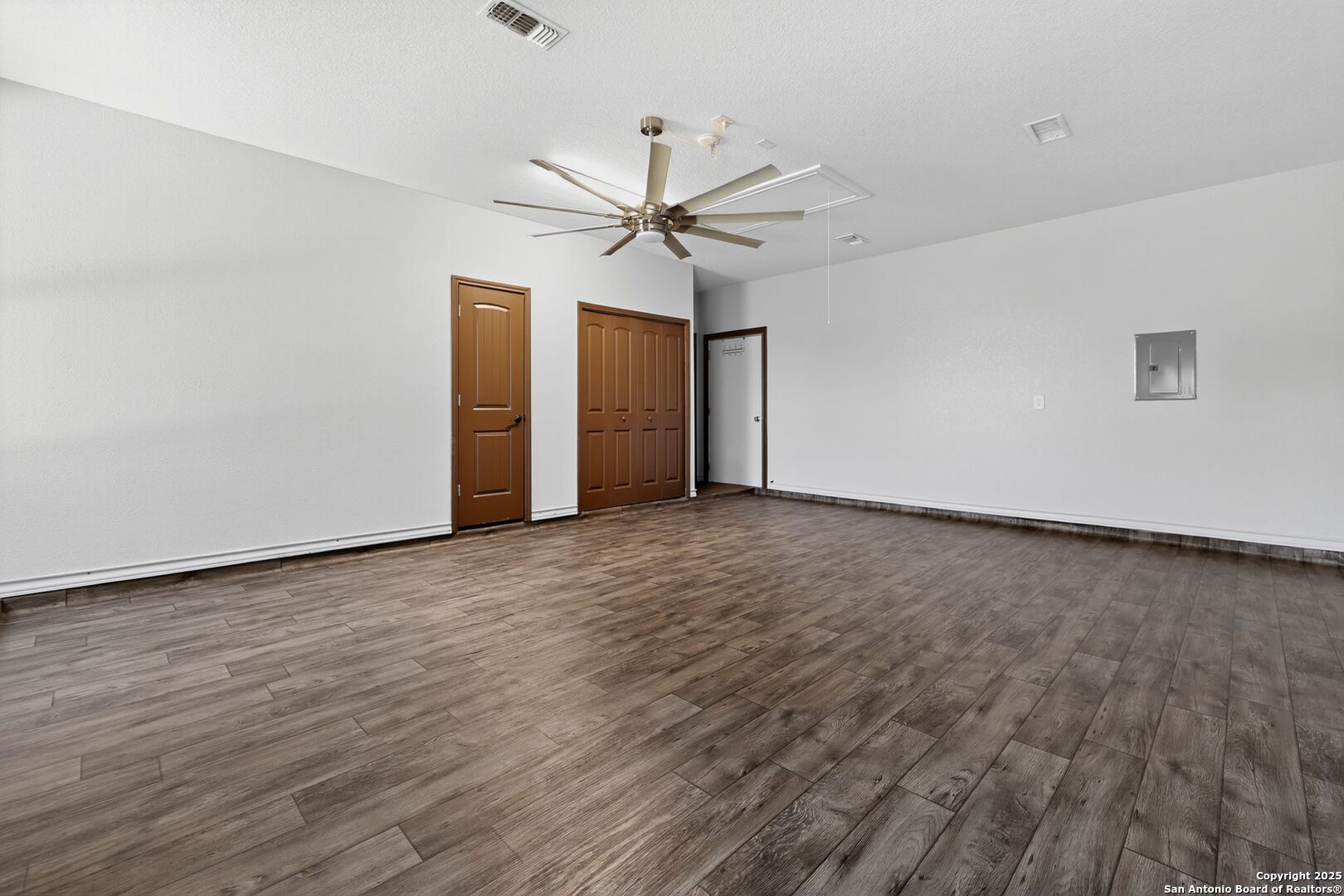 101 Lucky Bandera, TX 78003 - Photo 15 of 42 an empty room with wooden floor ceiling fan and windows