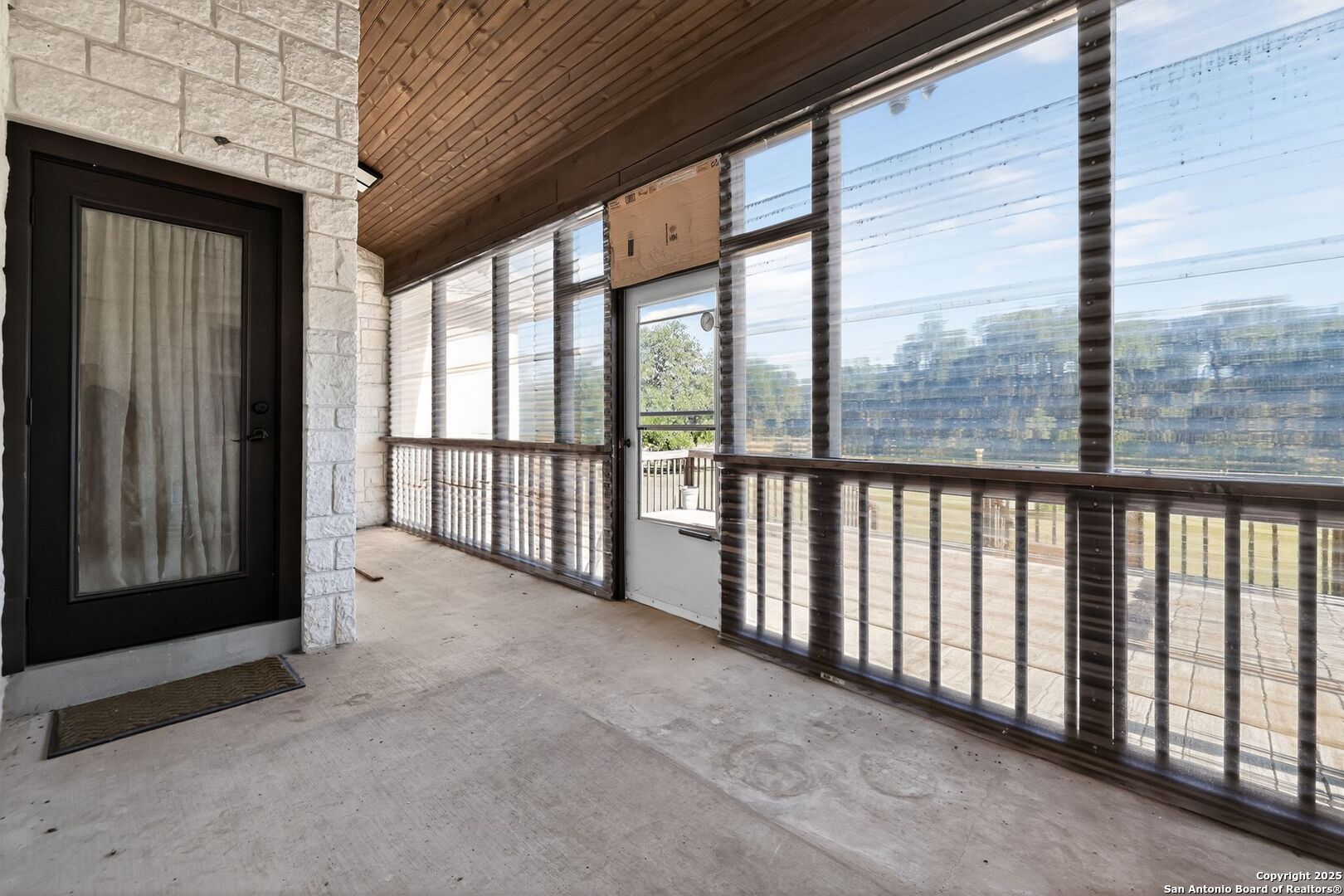 101 Lucky Bandera, TX 78003 - Photo 33 of 42 a view of a porch with wooden floor and floor to ceiling window