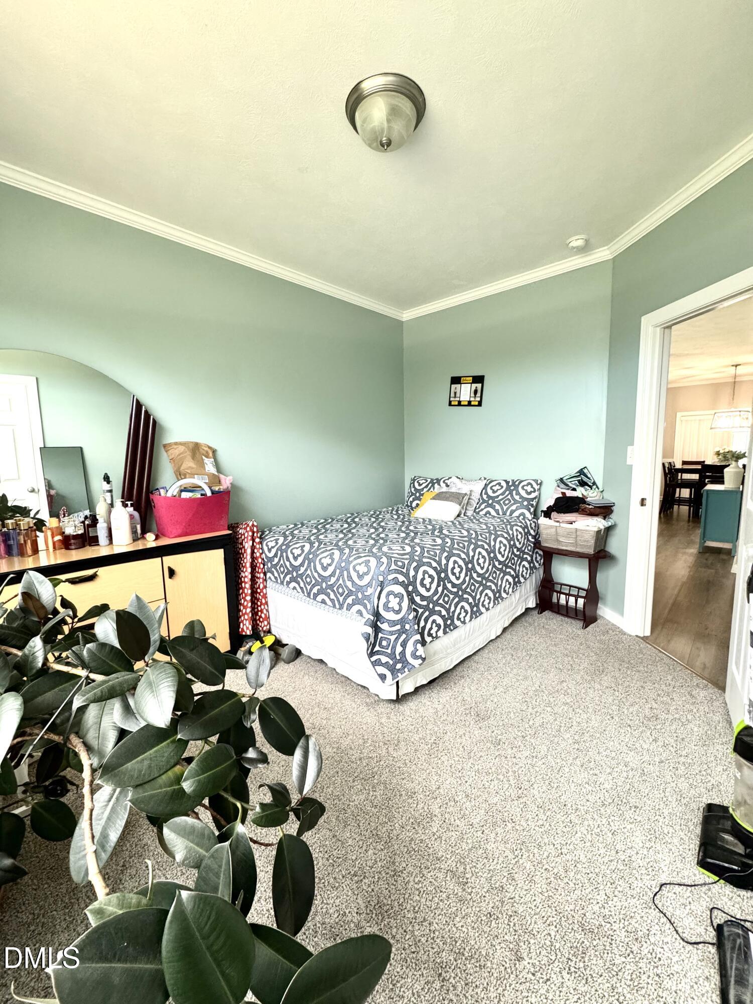 640 Tart Town Road Dunn, NC 28334 - Photo 40 of 71 a bedroom with bed and a chandelier