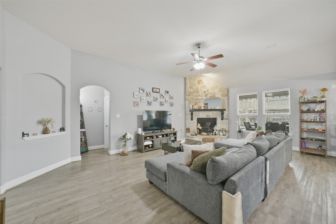 30014 Valley Terrace Drive Fulshear, TX 77406 - Photo 11 of 35 a living room with furniture a fireplace and a chandelier
