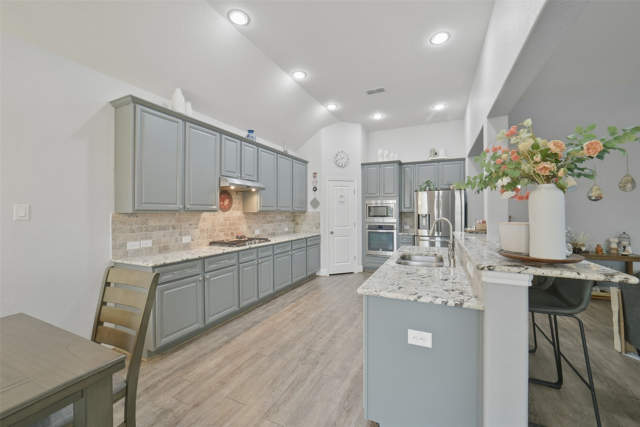 30014 Valley Terrace Drive Fulshear, TX 77406 - Photo 15 of 36 This kitchen is a chef's dream! There are granite counters with tile backsplash, high ceilings, LED recessed lighting and a walk-in pantry.