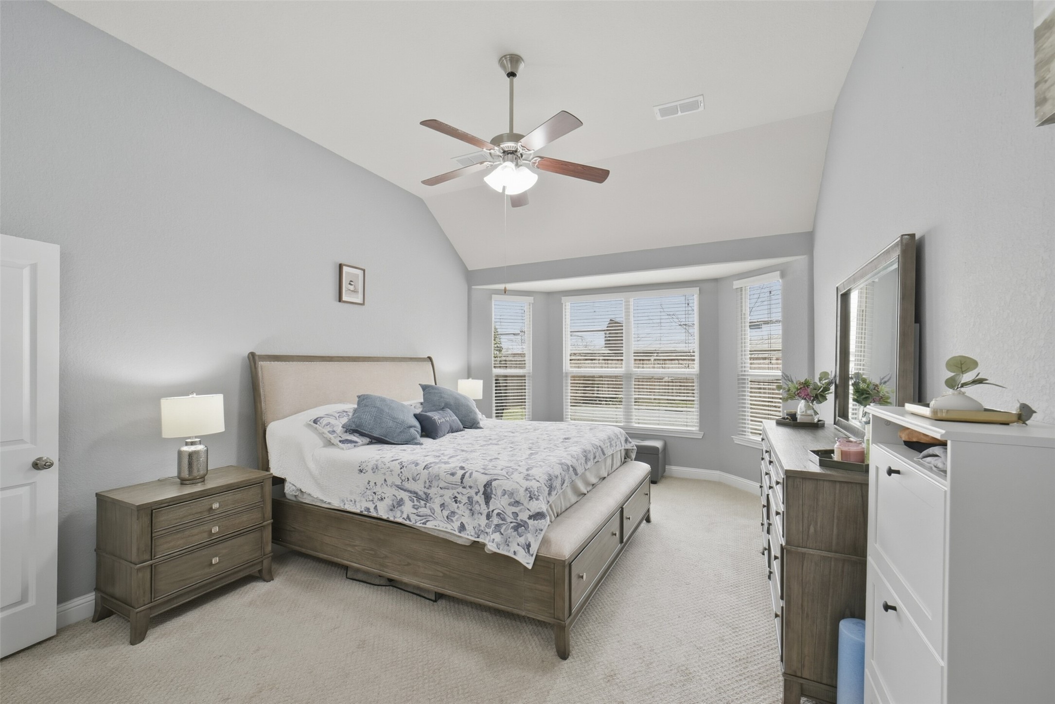 30014 Valley Terrace Drive Fulshear, TX 77406 - Photo 22 of 36 The primary bedroom is located on the first floor with carpet, a ceiling fan, high ceilings, and views of the backyard through the double pane windows.