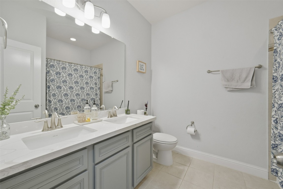 30014 Valley Terrace Drive Fulshear, TX 77406 - Photo 28 of 35 a bathroom with a sink a toilet and a large mirror