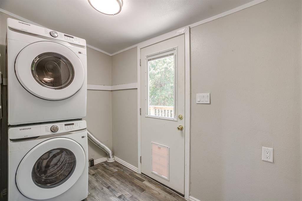 178 Valley Lake Lane Springtown, TX 76082 - Photo 15 of 33 Dedicated laundry area featuring stacked front-load machines, wood-finish flooring, and a rear exit door with a clear glass insert