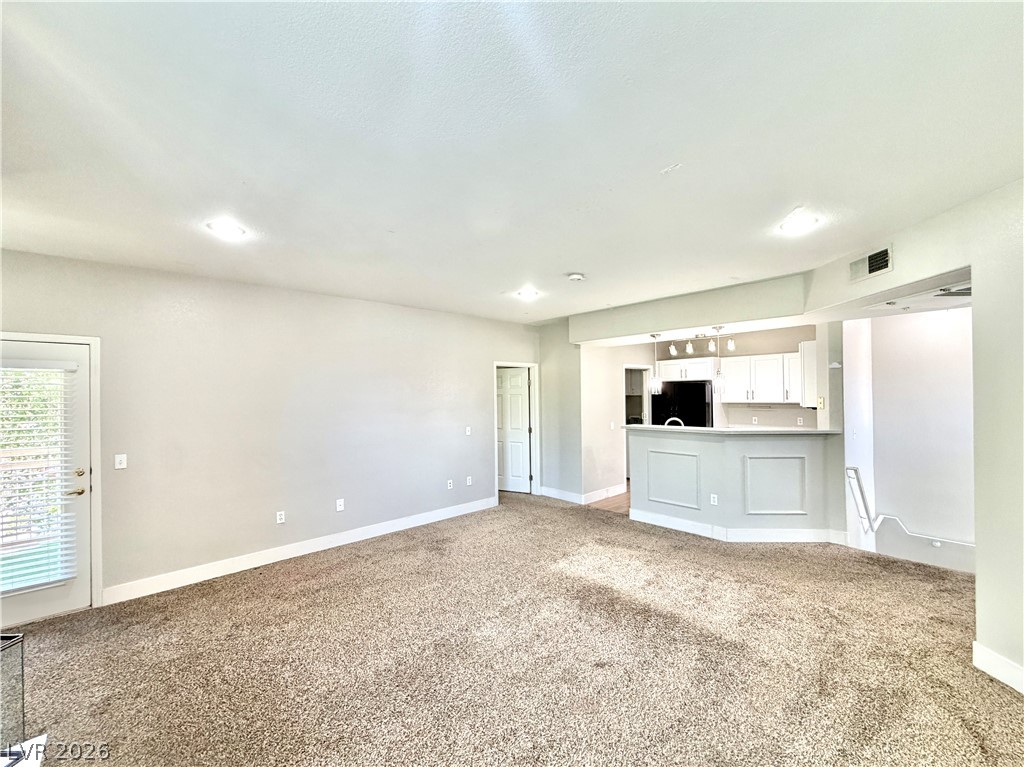 8555 West Russell Road, Unit 2018 Las Vegas, NV 89113 - Photo 8 of 23 A versatile living space with plush carpeting, offering a seamless flow to the well-appointed kitchen.