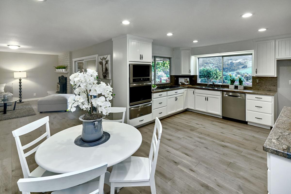 20421 Hunter's Hill Road San Jose, CA 95120 - Photo 24 of 50 a kitchen with stainless steel appliances kitchen island granite countertop a dining table chairs and microwave