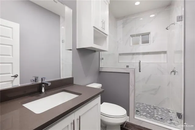 a bathroom with a sink a toilet and shower