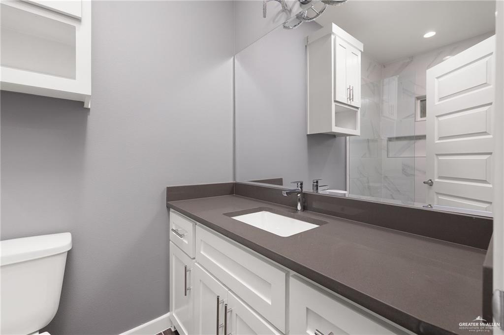 1721 Monaco Drive, Unit 4 San Juan, TX 78589 - Photo 13 of 17 a bathroom with a sink a toilet and a mirror