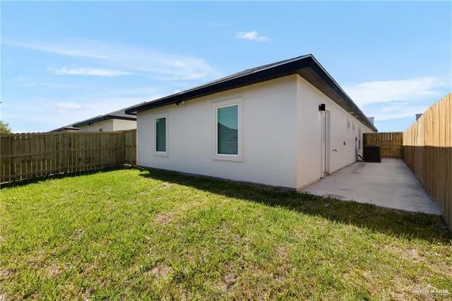 a view of backyard of house with wooden fence