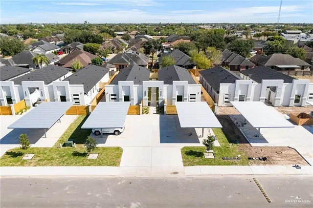 an aerial view of residential houses with outdoor space and street view