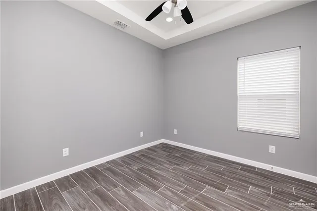 an empty room with a window and ceiling fan