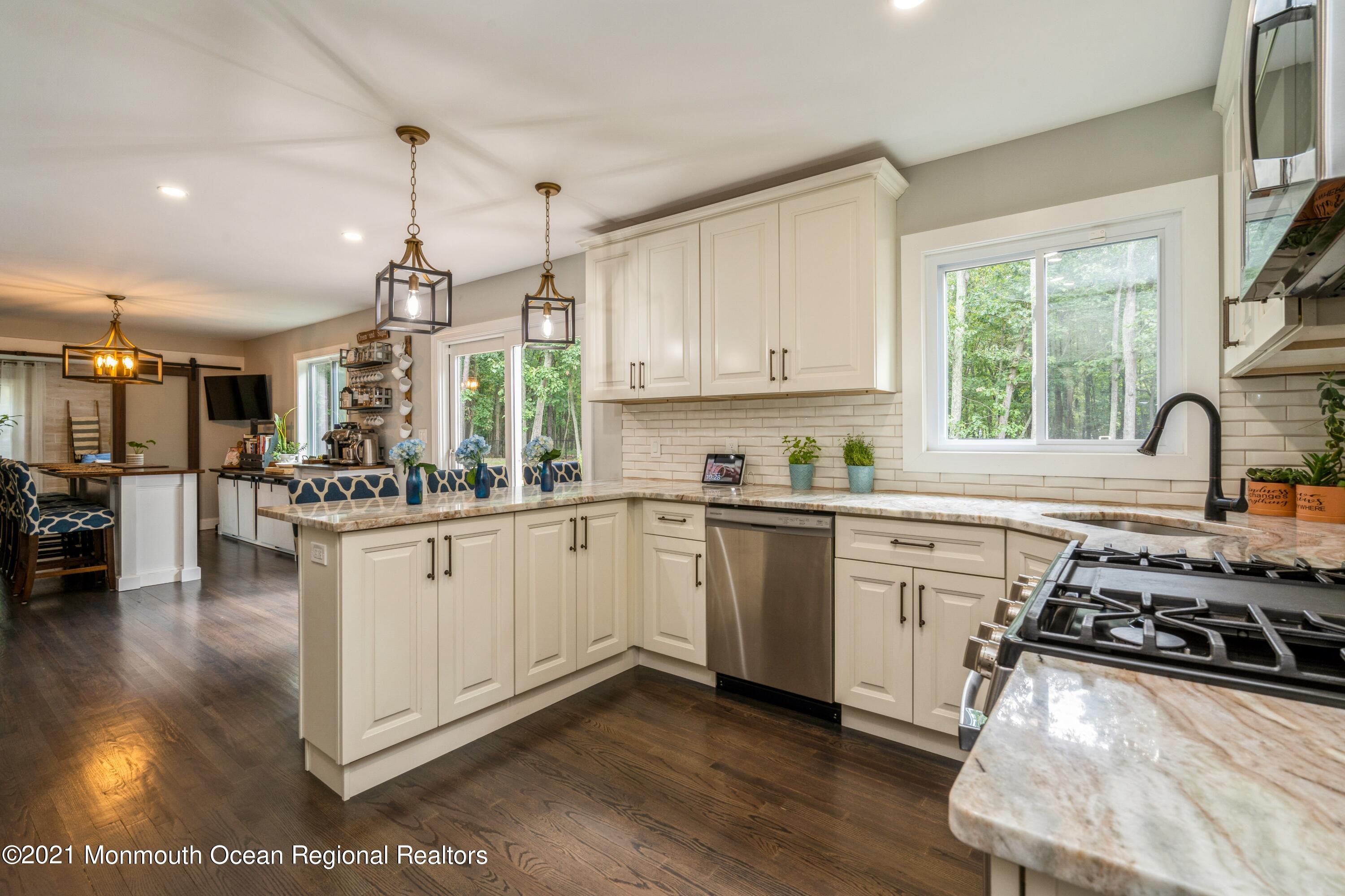 6 Brookside Road Millstone Township, NJ 08510 - Photo 8 of 27 a kitchen with stainless steel appliances granite countertop a stove a sink dishwasher a refrigerator and white cabinets with wooden floor