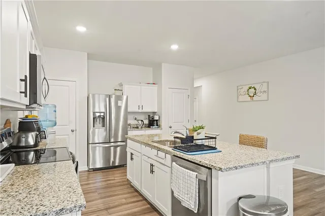 a kitchen with stainless steel appliances granite countertop a sink stove and refrigerator