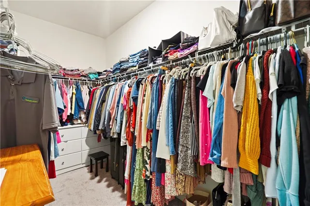 a view of walk in closet with clothes