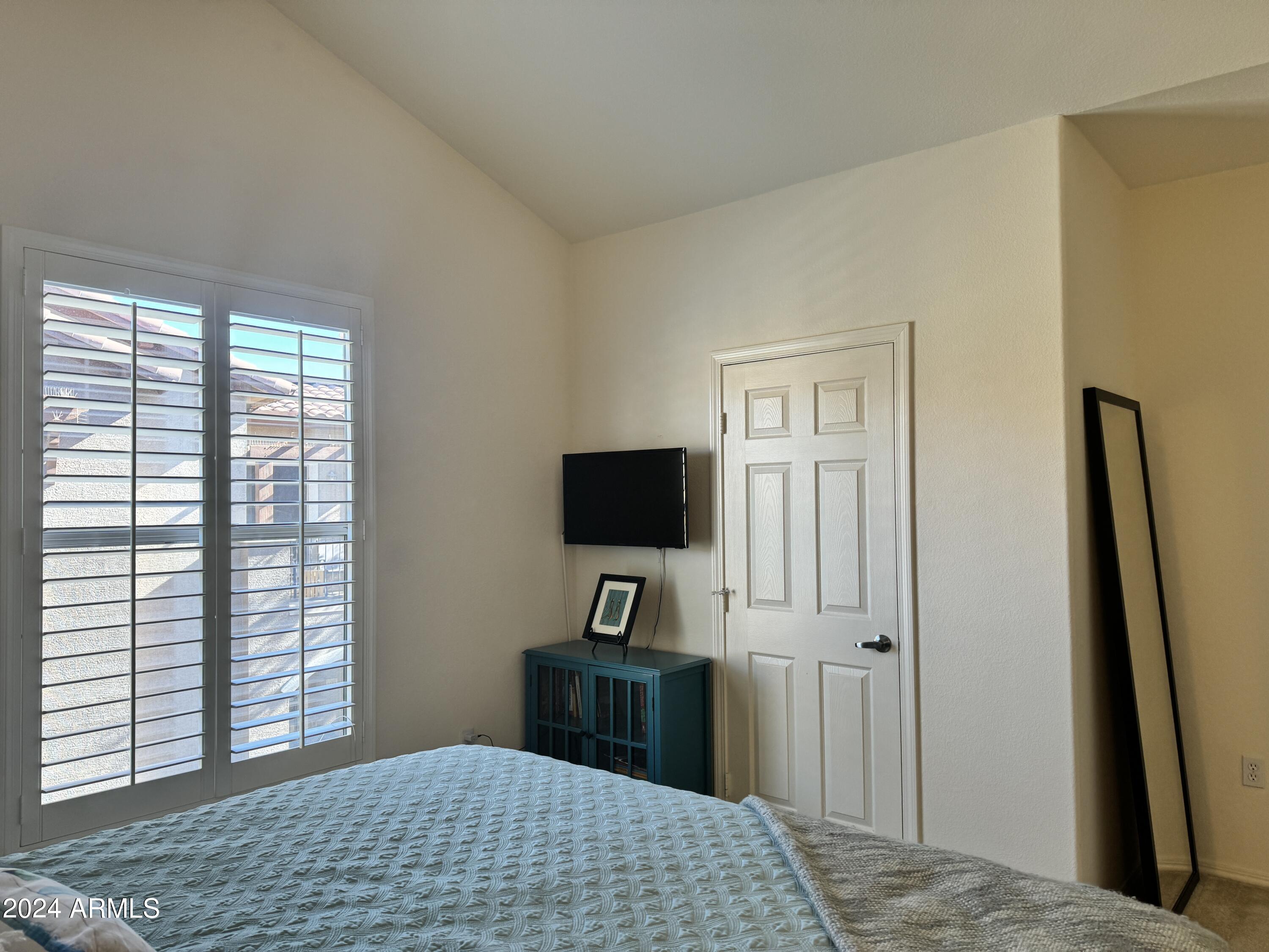 14250 West Wigwam Boulevard, Unit 1421 Litchfield Park, AZ 85340 - Photo 12 of 15 a bedroom with a bed and a flat screen tv