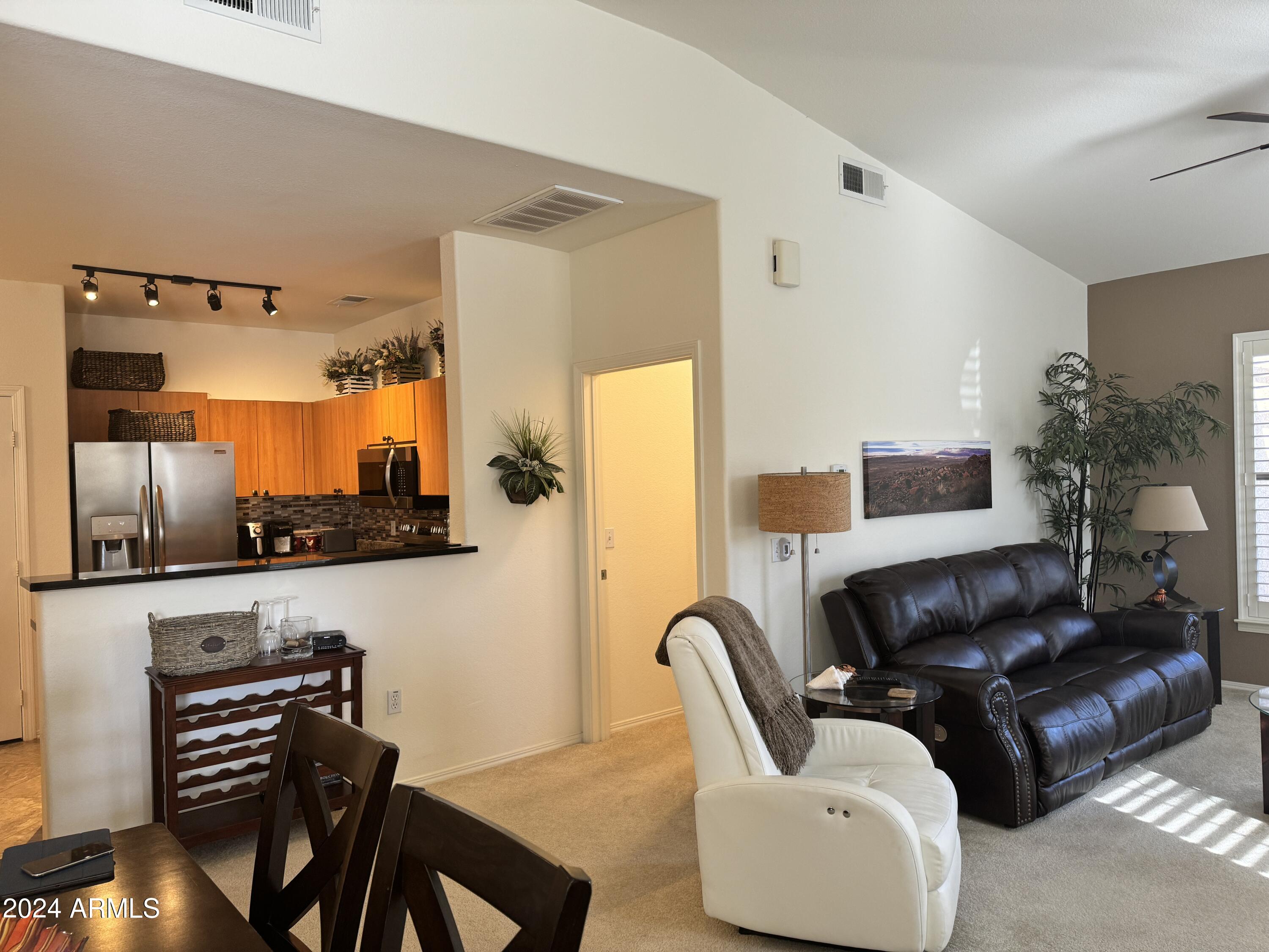 14250 West Wigwam Boulevard, Unit 1421 Litchfield Park, AZ 85340 - Photo 5 of 15 a living room with furniture and a flat screen tv