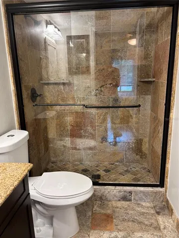 a bathroom with a toilet and a shower
