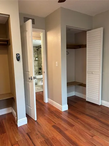 a view of a hallway with wooden floor and closet