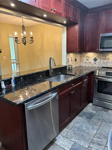 a kitchen with granite countertop a sink and cabinets