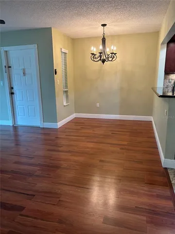 a view of a room with wooden floor and chandelier