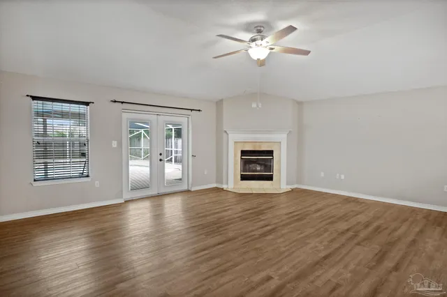 a view of an empty room with a fireplace and a window