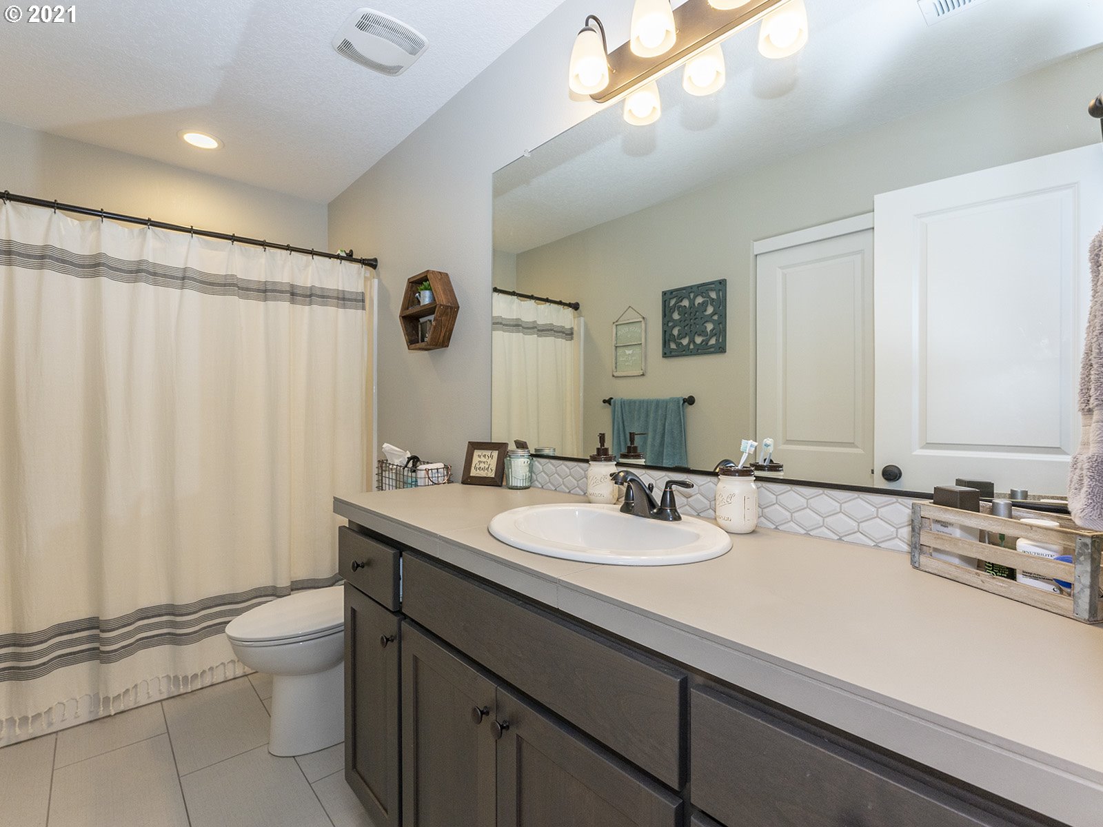 2813 Southeast Baker Avenue Gresham, OR 97080 - Photo 25 of 32 a bathroom with a double vanity sink toilet and a mirror