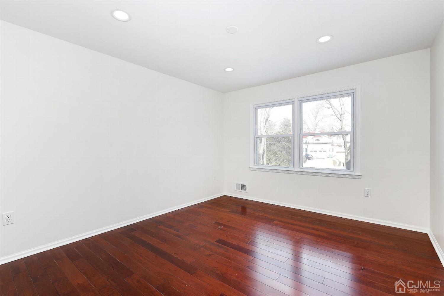 1 Paddock Court Edison, NJ 08820 - Photo 8 of 18 an empty room with wooden floor and windows