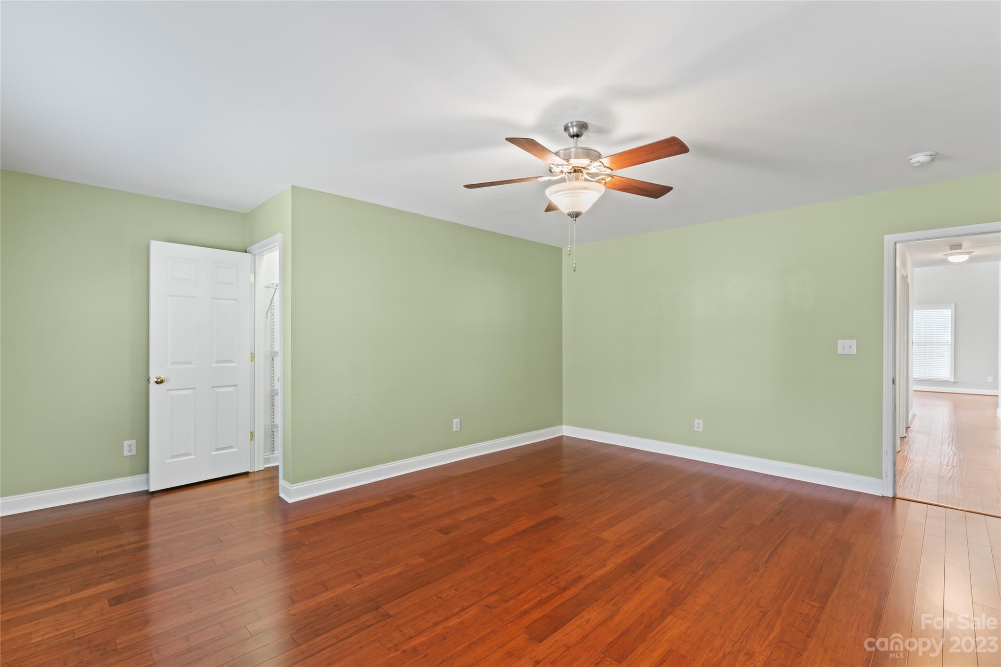 3205 McGee Lane Monroe, NC 28110 - Photo 18 of 34 an empty room with wooden floor and a ceiling fan