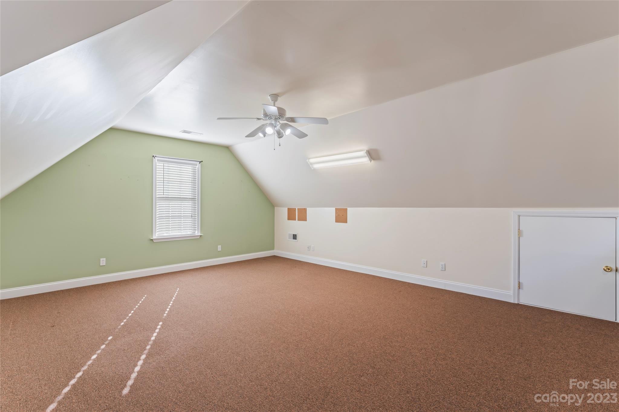 3205 McGee Lane Monroe, NC 28110 - Photo 27 of 34 an empty room with a chandelier fan and windows